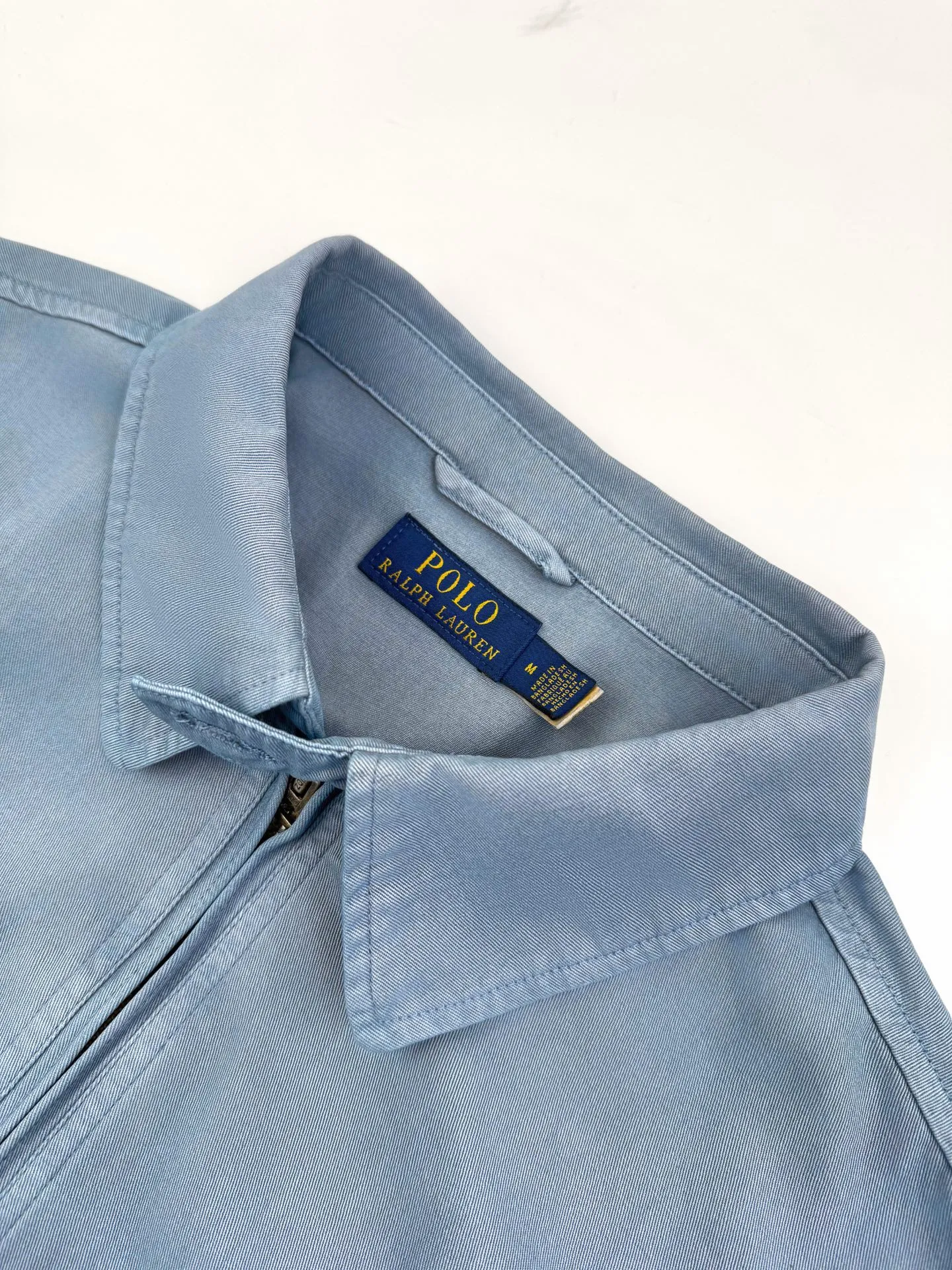 P460 Ralph Lauren embroidered zipper jacket. Customized cloudy blue twill cotton. Soft and silky. Comfortable against the skin. Mainly based on cloudy blue. A color with a life attitude. Exquisite white pony logo is embellished. Fully recognizable. With a breath of freedom and vitality. A symphony of pure and smart colors. Reconstruct the classic with a neat silhouette. Use advanced computer control systems and precision mechanical components to achieve iconic pony embroidery operations with high precision and smooth and delicate lines. Process 2: Template machine bag opening. The preset template guides the position, shape and size of the bag opening. The accuracy ensures the quality of the bag opening effect. Process 3: The hem is made in one go using a three-needle waist-drawing machine. The elastic band and fabric are sewn together in the same process using the machine's special needle position and feeding mechanism. The three-needle design is stronger and can evenly distribute pressure. Ensure that the elastic band is closely attached to the fabric. Process 4: Follow the original color system for dyeing. Prioritize the original color and fabric material. Select special dyes. Reheat to the appropriate temperature. Perform dip-dyeing. Finally, perform color registration. Accessories: Customized 1:1 Ralph Lauren engraved buckle. Customized 1:1 Ralph Lauren bronze zipper. Customized 1:1 Ralph Lauren trademark. Version: Fitted version. Size: S M L XL. Style number: CC908.
